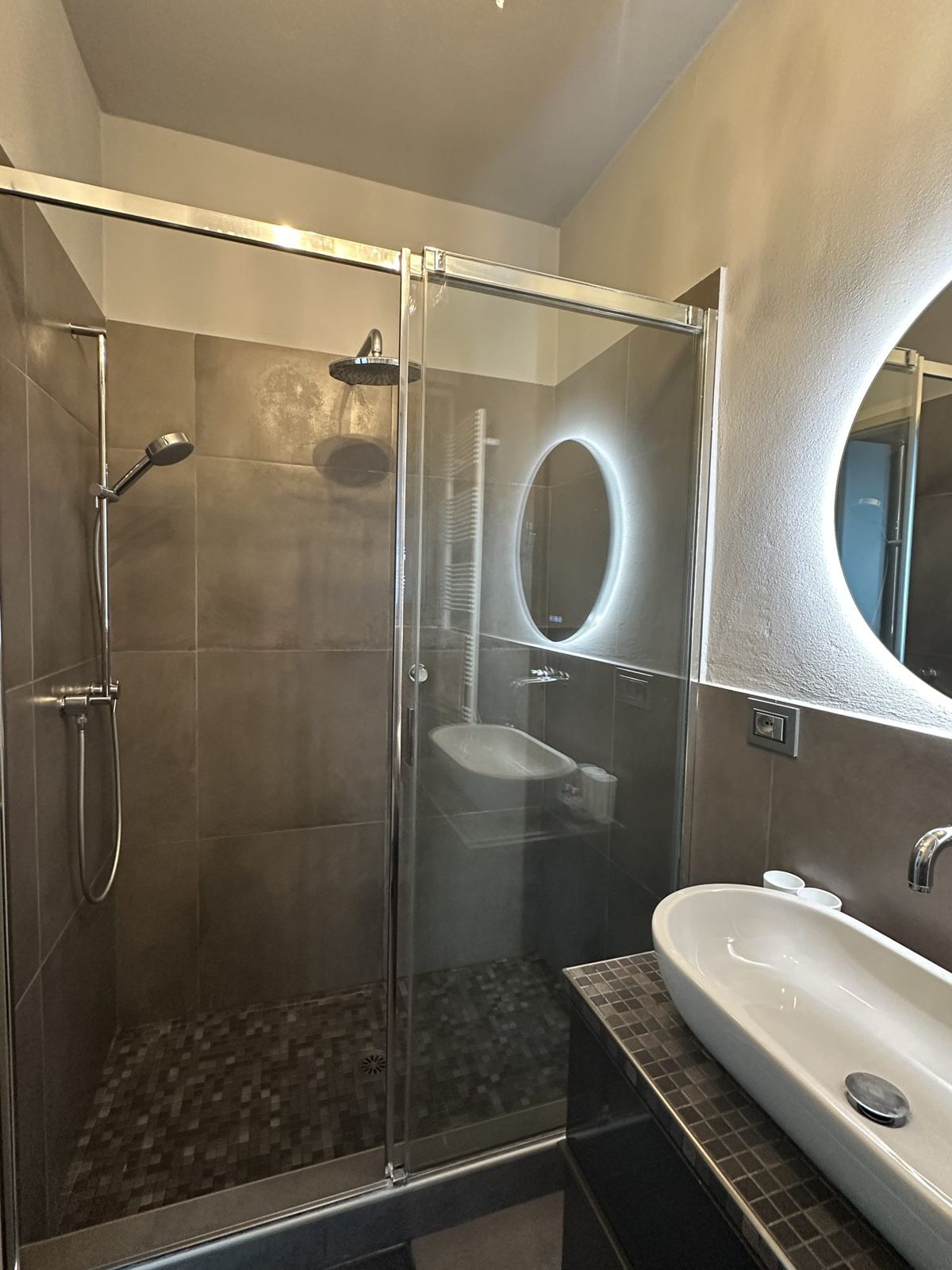 Bagno con doccia in cristallo e specchio retroilluminato