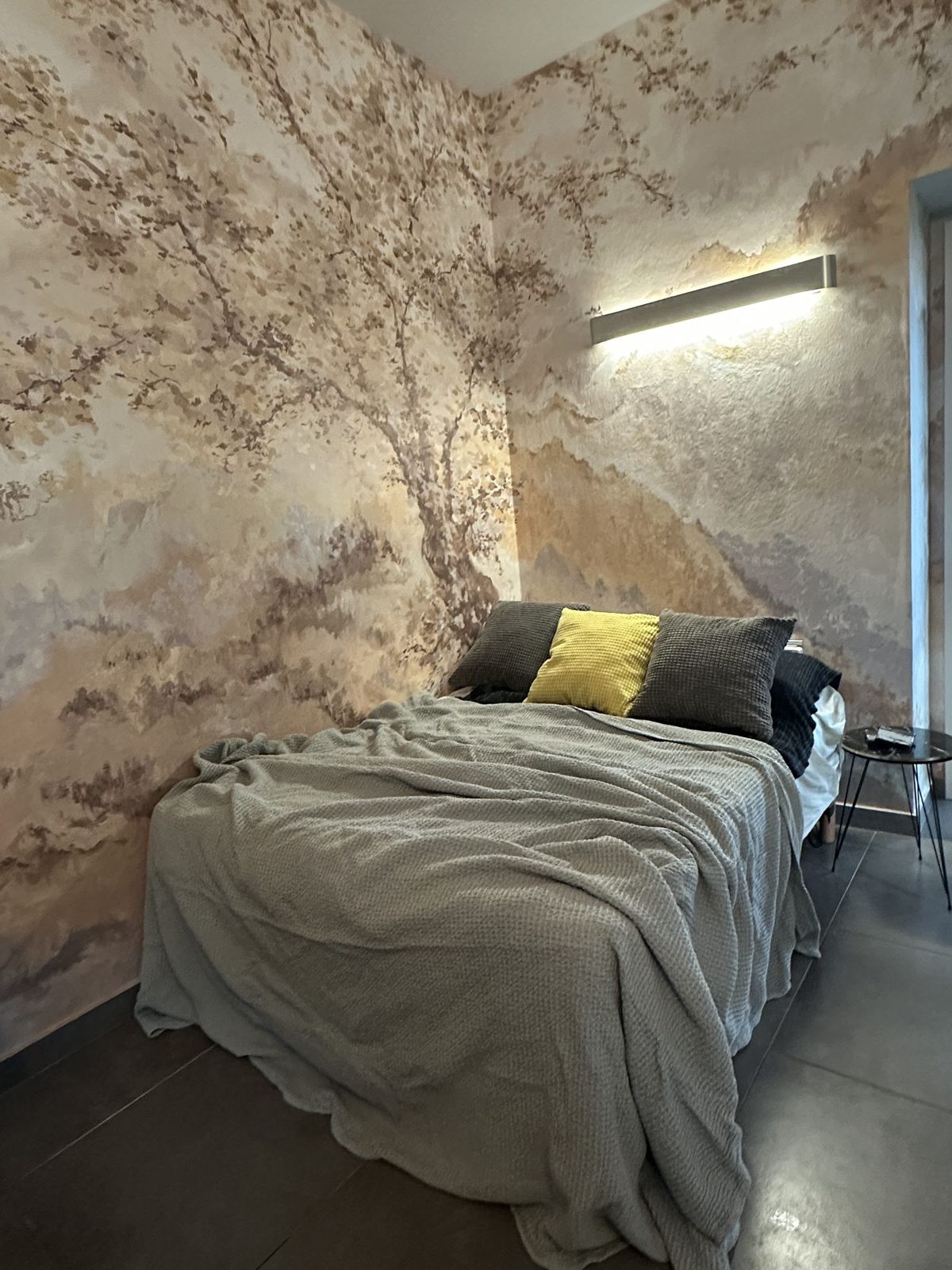 Zona notte con murale e cuscino giallo