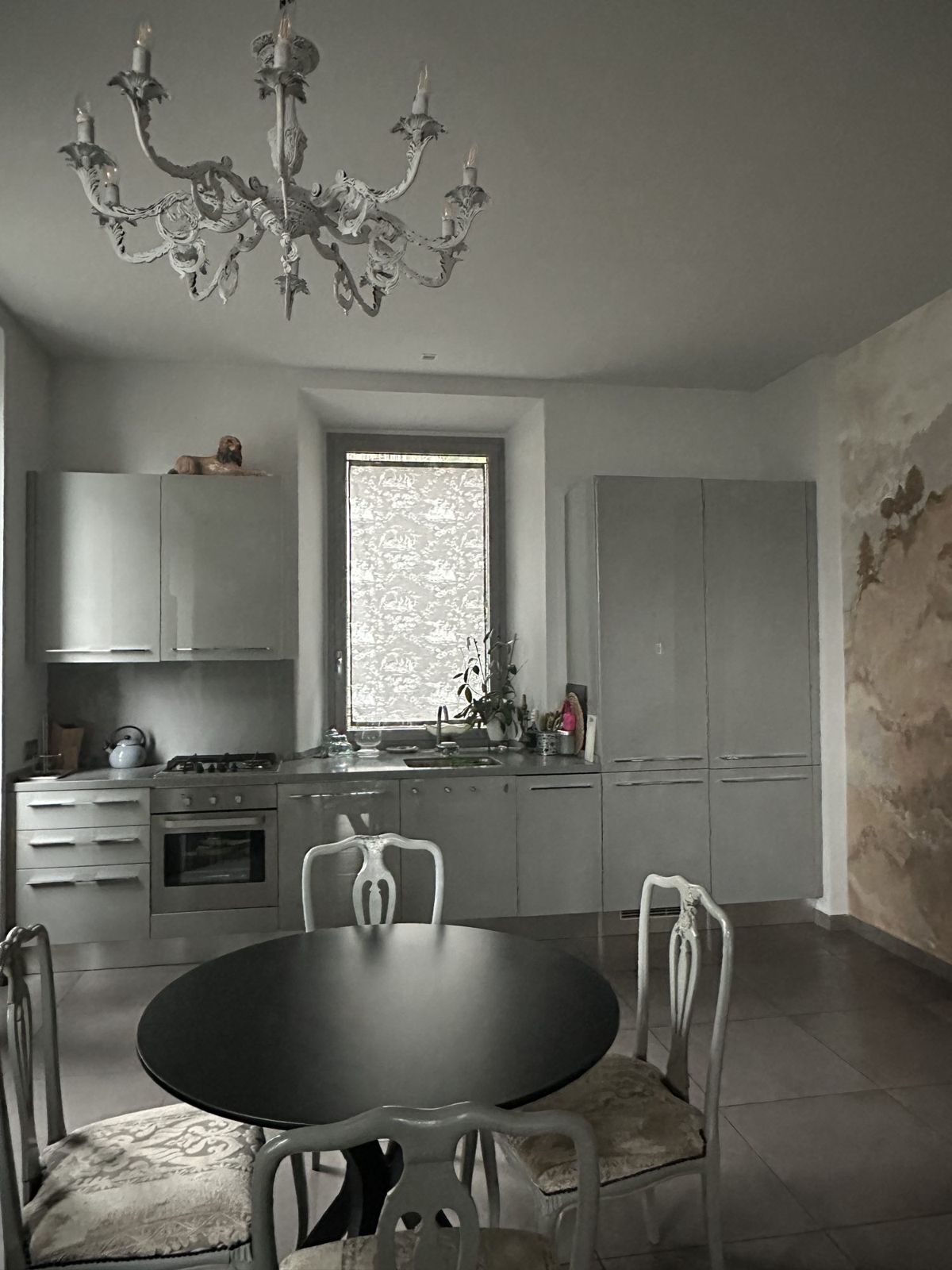 Cucina con tavolo rotondo nero e sedie bianche
