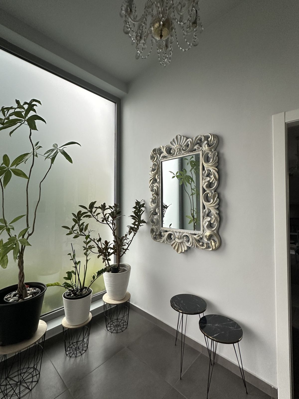 Ingresso con piante, vetrata e specchio barocco bianco